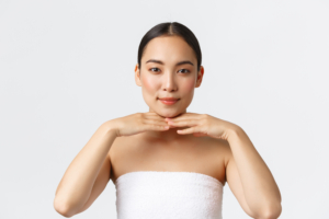 Asiatische Frau stützt ihr Kinn mit den Armen und blickt geradeaus