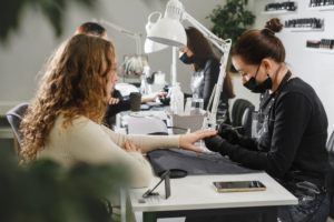 Maniküre-Salon. Professioneller Manikürist, der Maniküre für Frauen macht