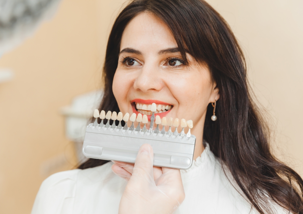 Frau bei der Auswahl der richtigen Zahnfarbe für die professionelle kosmetische Aufhellung beim Zahnarzt.