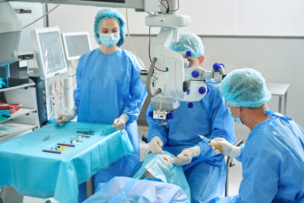 Team von Ärzten in OP-Gewand behandelt Patienten auf dem OP-Tisch