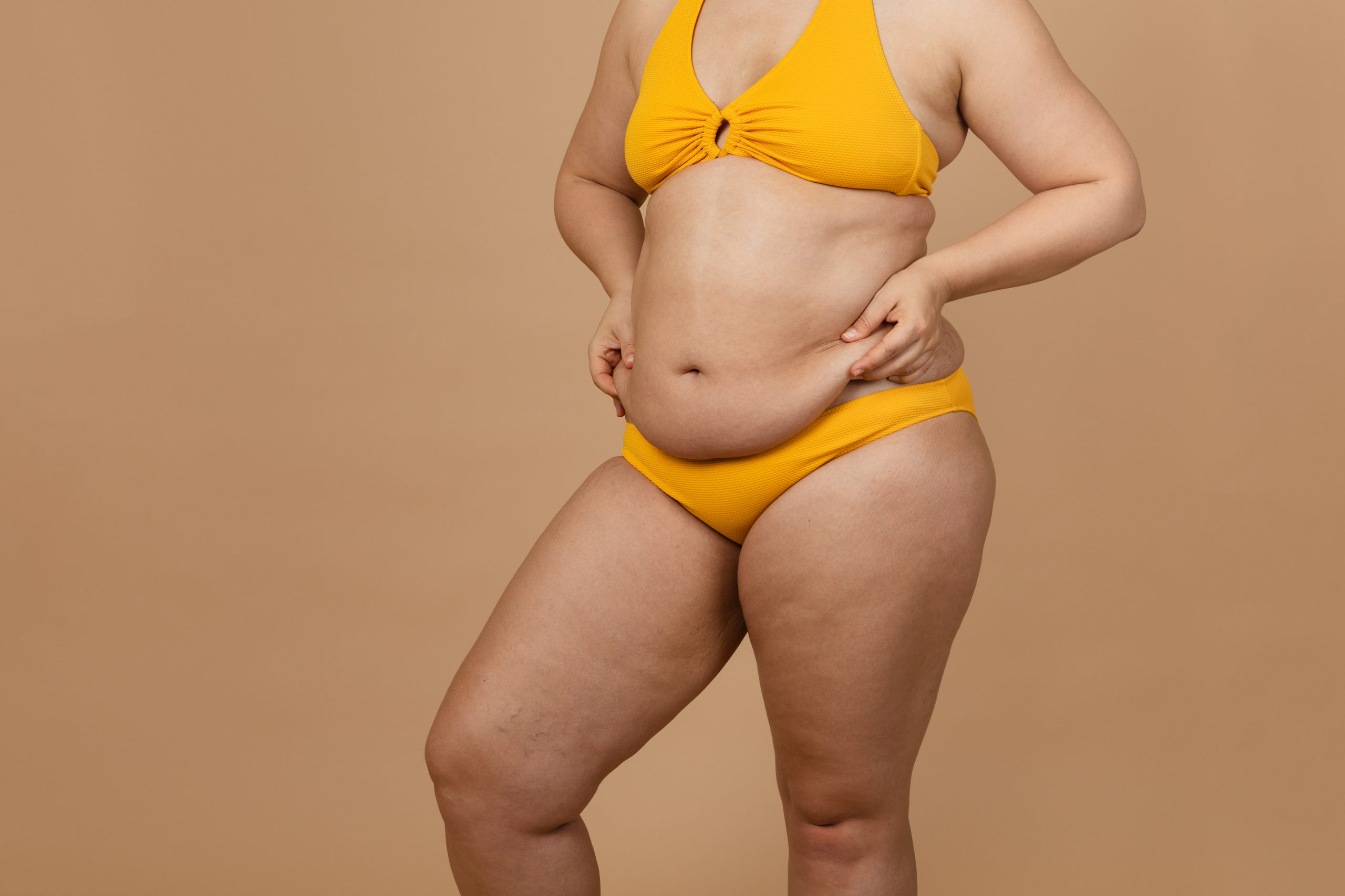 Frau in Bikini greift sich auf ihren Bauch