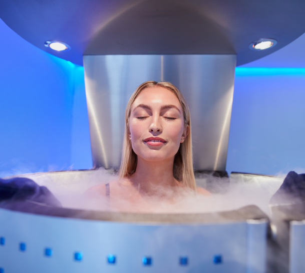 Frau sitzt mit ihrem ganzen Körper in einer Kyrotherapie-Kabine