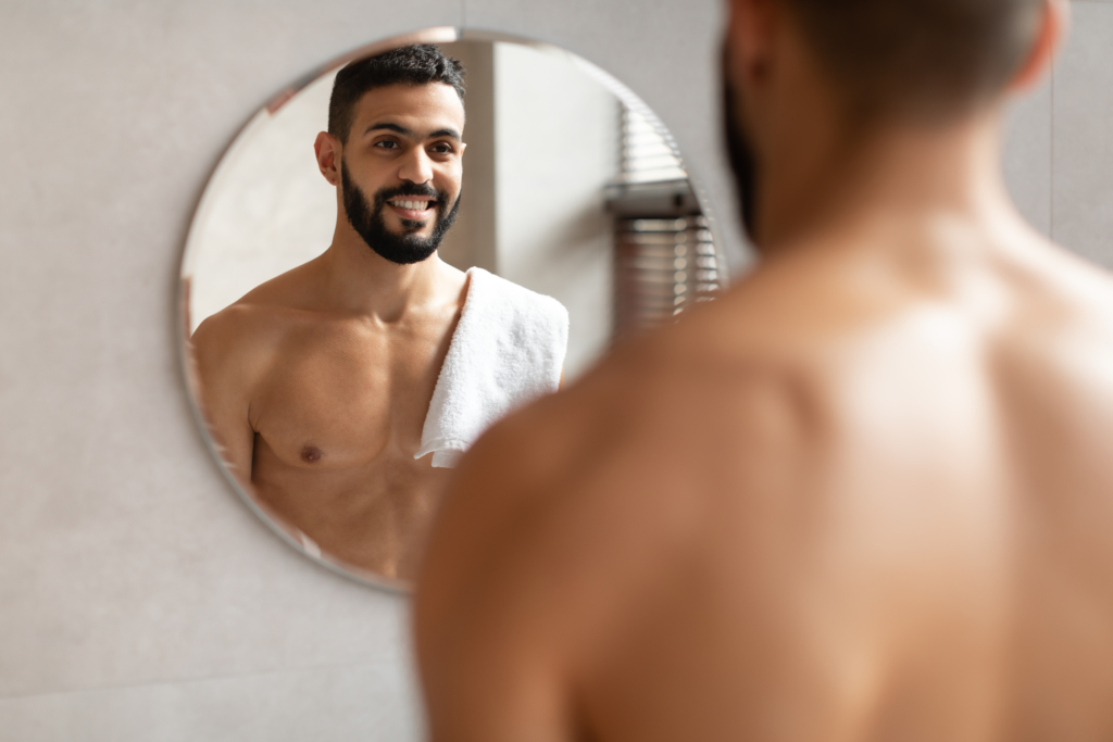 Selbstbewusster junger Araber schaut in den Spiegel
