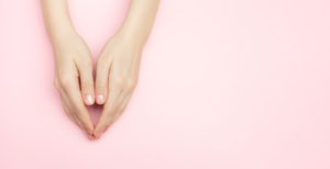 Hände gefaltet auf einem rosa Hintergrund