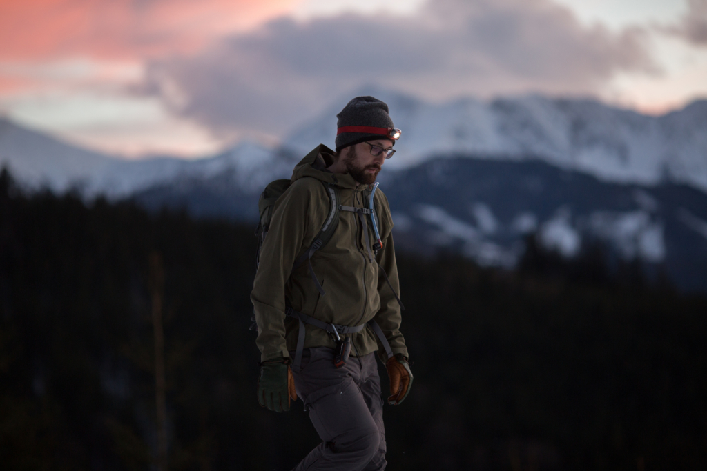 Mann mit Mütze und Stirnlampe geht wandern