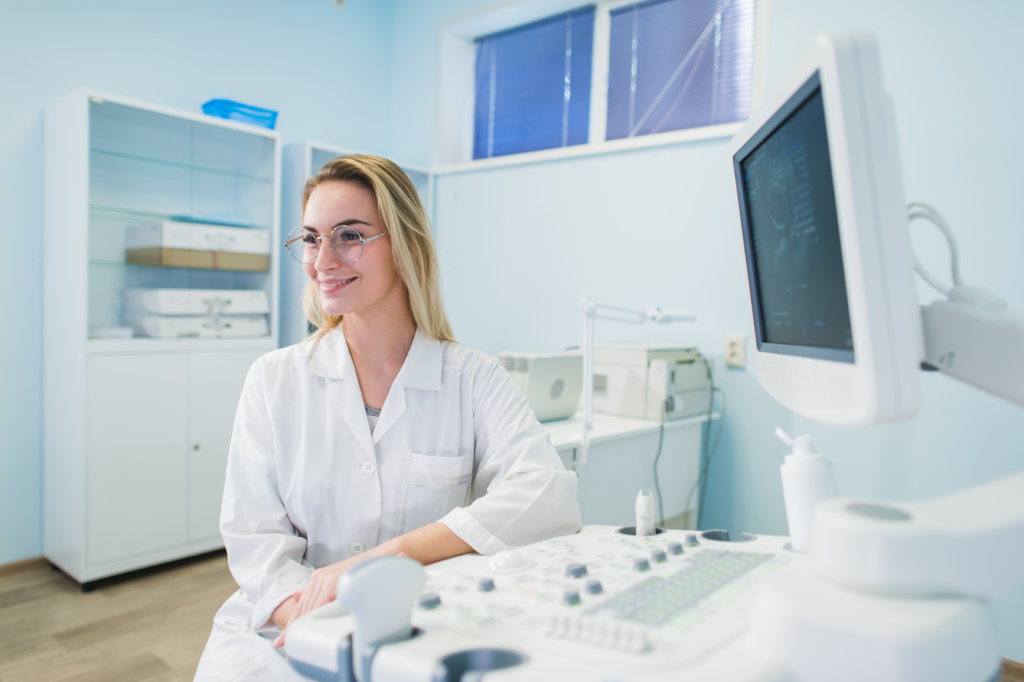 Frau sitzt neben einem Ultraschallgerät