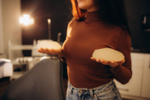 Eine Frau hält zwei Brustimplantate