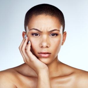 Frau in Nahaufnahme hält eine Hand an ihr Gesicht seitlich