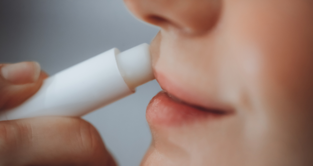 Frau trägt sich Lippenbalsam auf