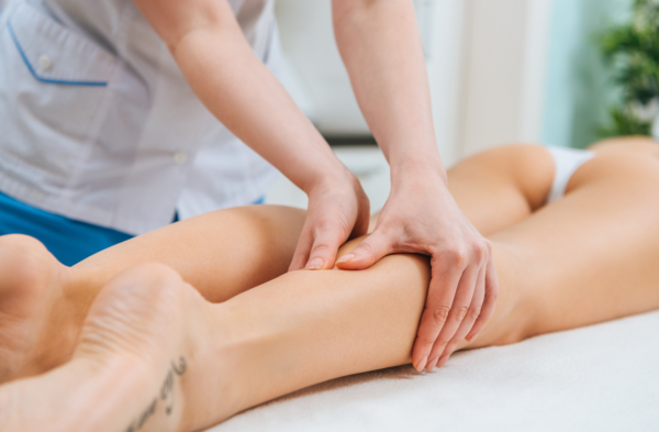 Frau wird an Beinen massiert