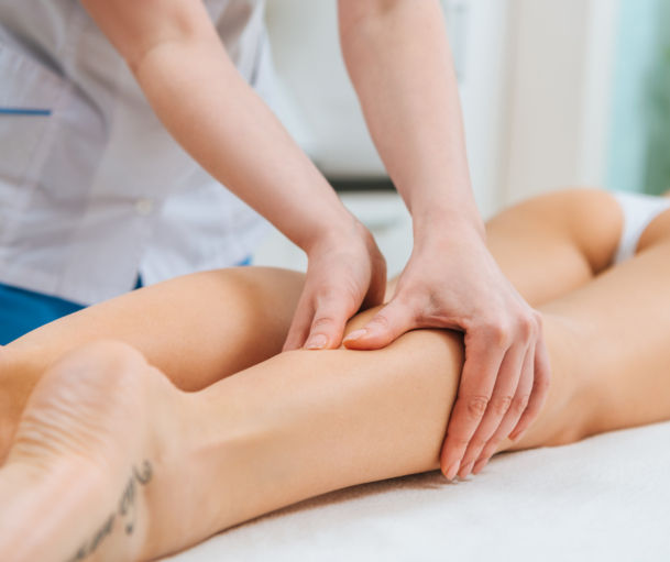 Frau wird an Beinen massiert