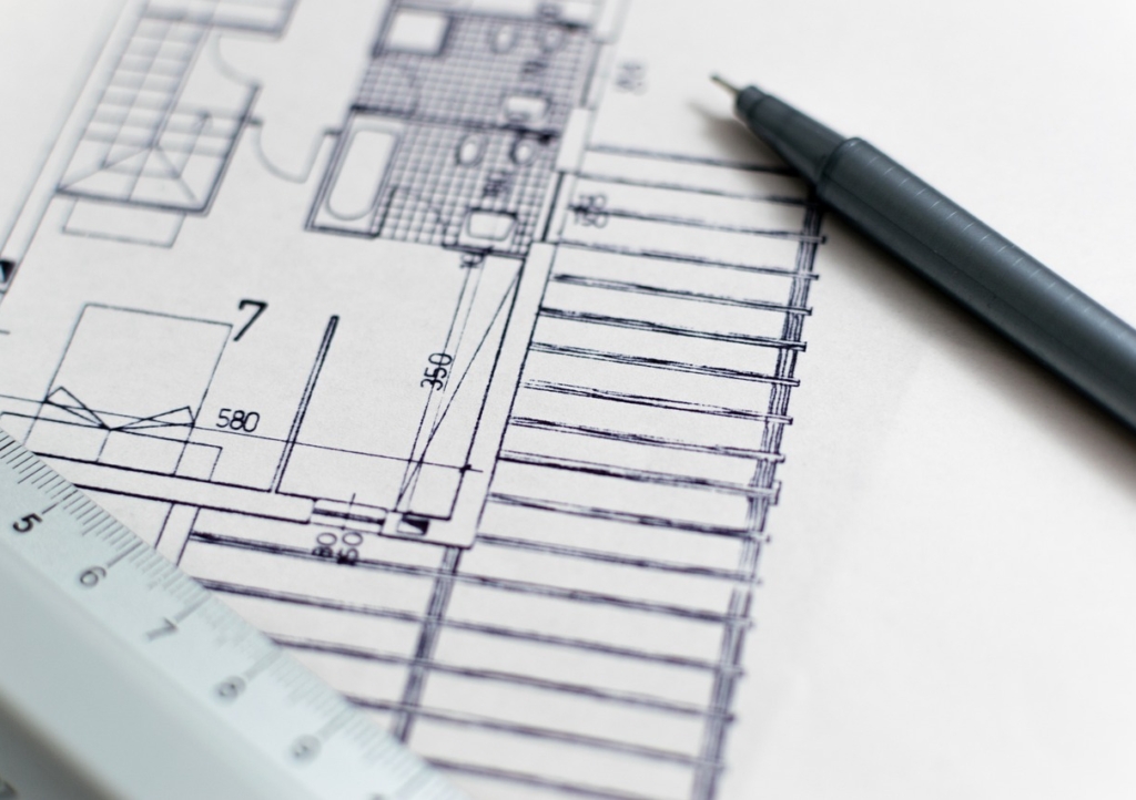Hände halten einen Bauplan in einem hellen Behandlungsraum, während die Baupreise 2026 für neue Praxisräume steigen – Foto: 3844328 / Pixabay