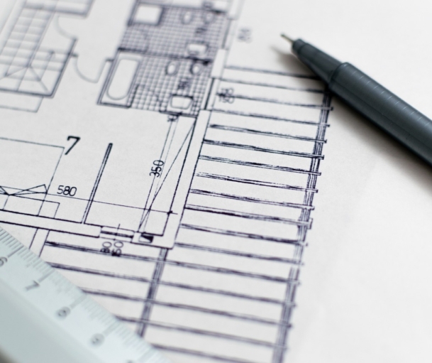 Hände halten einen Bauplan in einem hellen Behandlungsraum, während die Baupreise 2026 für neue Praxisräume steigen – Foto: 3844328 / Pixabay