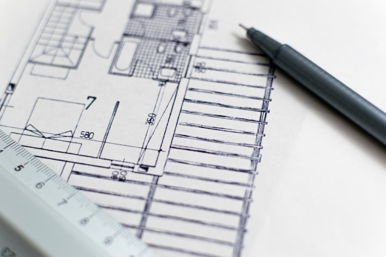 Hände halten einen Bauplan in einem hellen Behandlungsraum, während die Baupreise 2026 für neue Praxisräume steigen – Foto: 3844328 / Pixabay