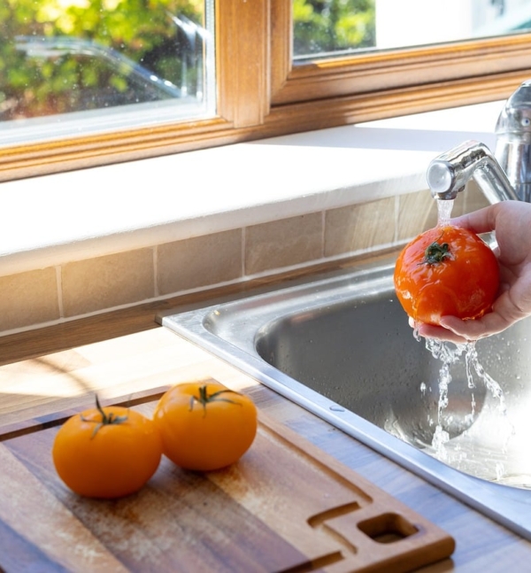 Hände waschen frisches Gemüse unter fließendem Wasser, um das Risiko einer Infektion mit Listerien zu senken – Foto: Irynkaa / Pixabay