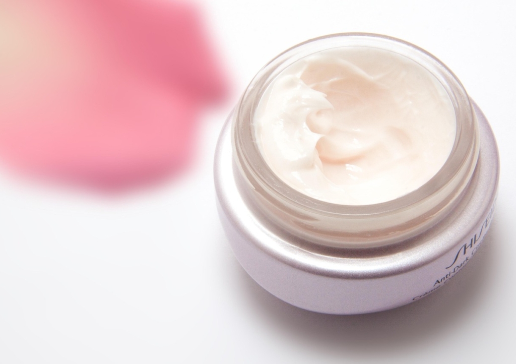Hände tragen Creme aus einem unbeschrifteten Tiegel auf, passend zum Trend um NIVEA Quartalszahlen und wachsende Hautpflegemarken – Foto: stux / Pixabay