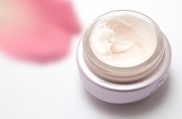 Hände tragen Creme aus einem unbeschrifteten Tiegel auf, passend zum Trend um NIVEA Quartalszahlen und wachsende Hautpflegemarken – Foto: stux / Pixabay